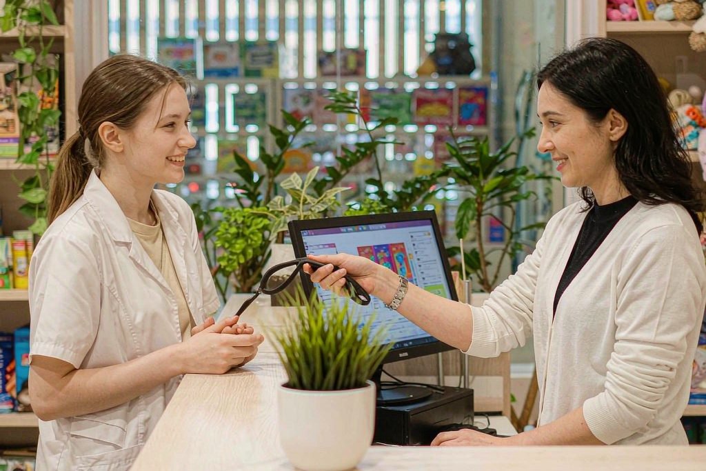 Two staff working at the counter with the POS screen on the till
